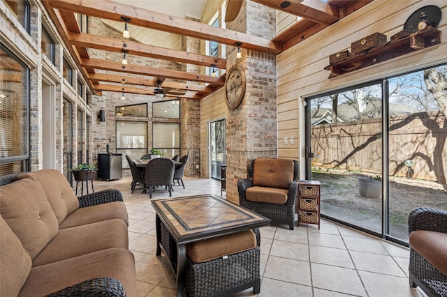 sunroom / solarium with beam ceiling and a ceiling fan