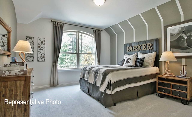 carpeted bedroom with lofted ceiling and baseboards