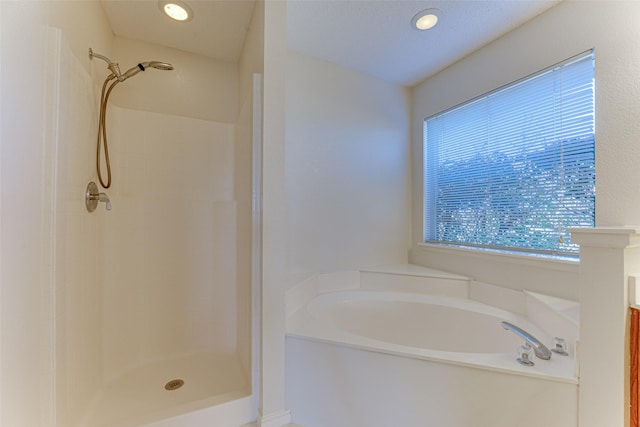 full bathroom featuring recessed lighting, a garden tub, and a shower stall