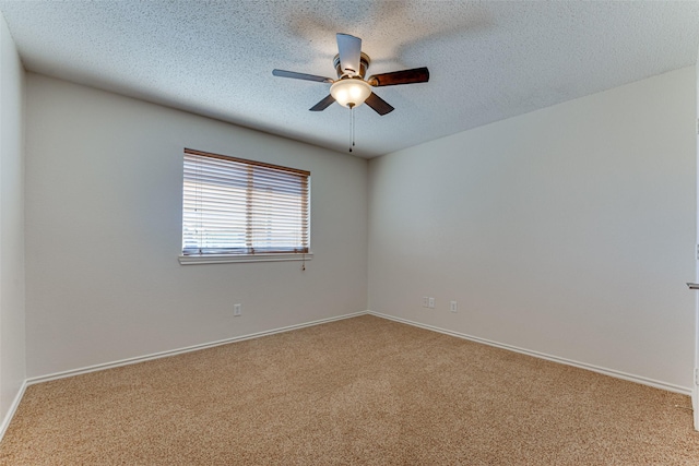 carpeted empty room with a ceiling fan, baseboards, and a textured ceiling