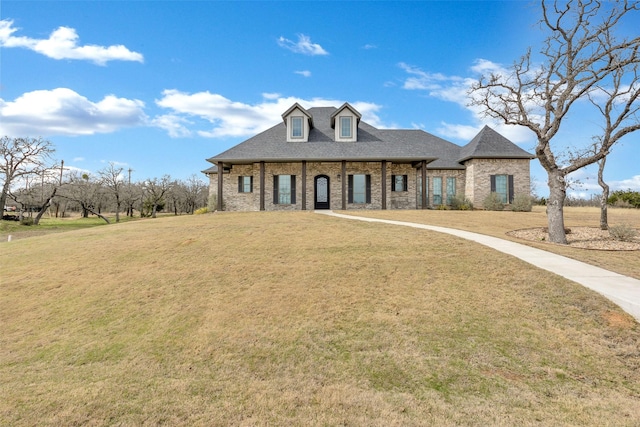 view of front of house with a front yard, brick siding, and a shingled roof