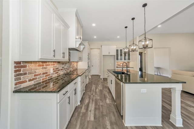 kitchen featuring a sink, stainless steel dishwasher, wood finished floors, decorative backsplash, and black electric stovetop