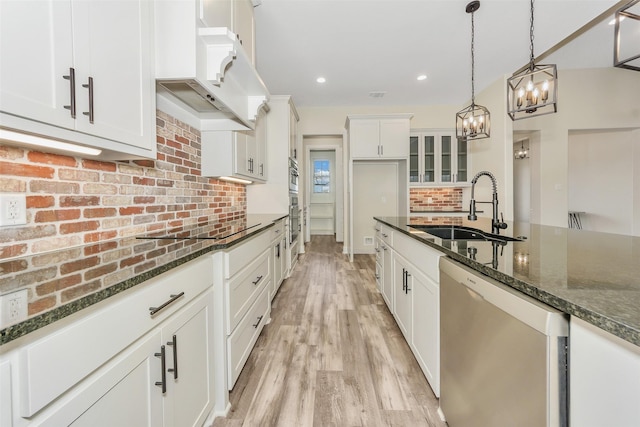 kitchen with backsplash, under cabinet range hood, stainless steel dishwasher, an inviting chandelier, and a sink