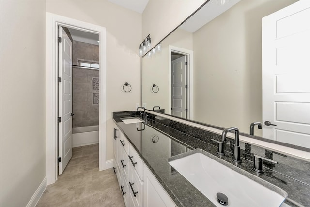 bathroom with a sink, baseboards, and double vanity