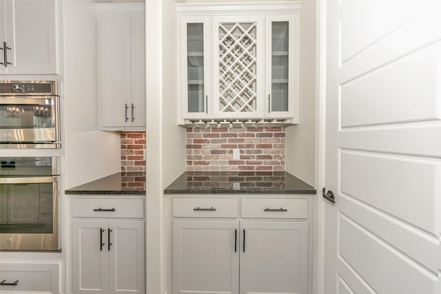 bar with stainless steel double oven and decorative backsplash