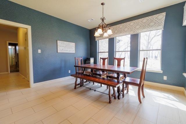 505 Spring Valley Rd, Paradise, TX 76073 - dining room with baseboards and an inviting chandelier