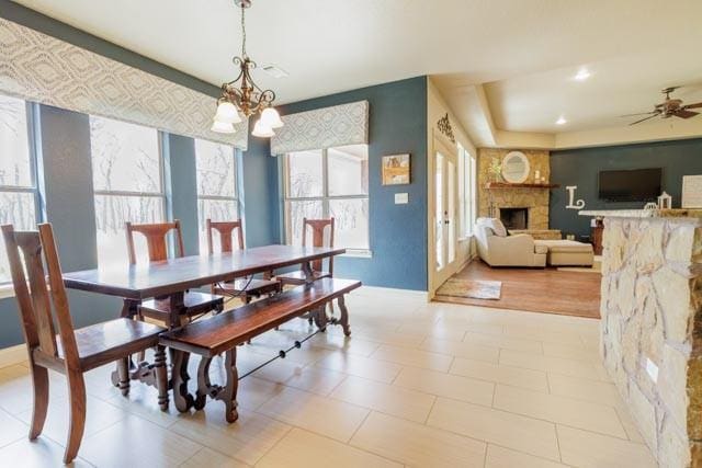 505 Spring Valley Rd, Paradise, TX 76073 - dining space with recessed lighting, a stone fireplace, a healthy amount of sunlight, and ceiling fan with notable chandelier