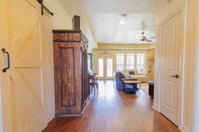 505 Spring Valley Rd, Paradise, TX 76073 - hallway with a barn door, wood finished floors, and visible vents