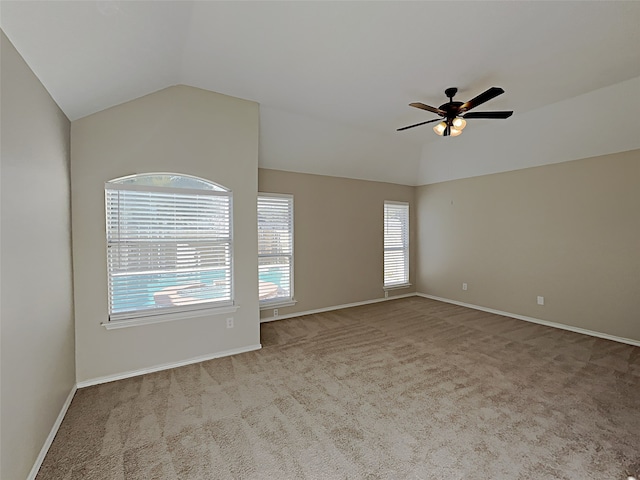 unfurnished room featuring vaulted ceiling, carpet, baseboards, and ceiling fan