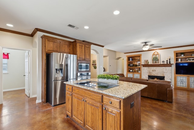 kitchen with visible vents, arched walkways, ceiling fan, stainless steel appliances, and a center island