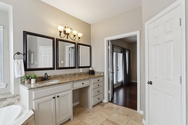 bathroom featuring a chandelier, tile patterned flooring, vanity, and a garden tub