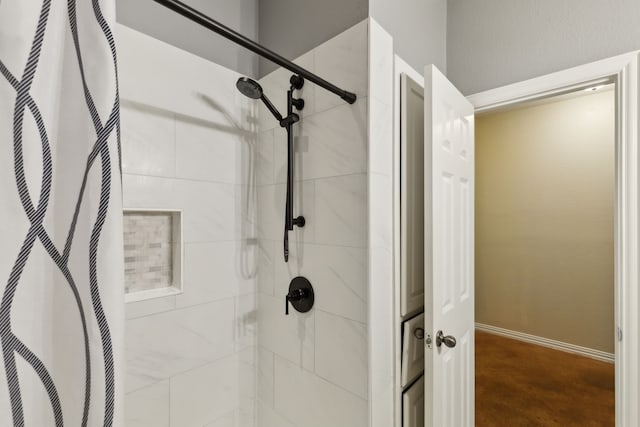 bathroom with a heating unit, baseboards, and a tile shower