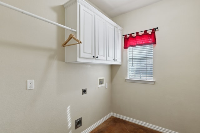 washroom with dark tile patterned flooring, washer hookup, cabinet space, baseboards, and hookup for an electric dryer