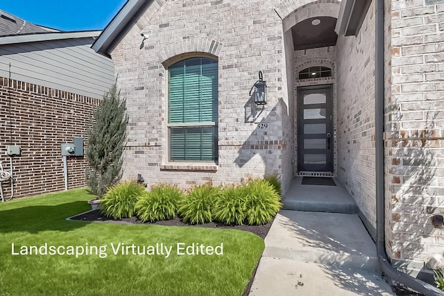 view of exterior entry with brick siding