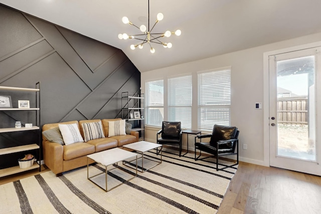 529 Hummingbird Dr, Celina, TX 75009 - living area featuring baseboards, a notable chandelier, lofted ceiling, wood finished floors, and a decorative wall
