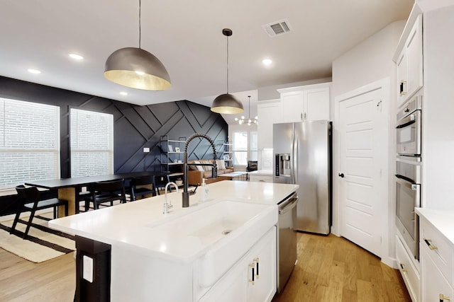 529 Hummingbird Dr, Celina, TX 75009 - kitchen featuring light wood finished floors, visible vents, a sink, and appliances with stainless steel finishes