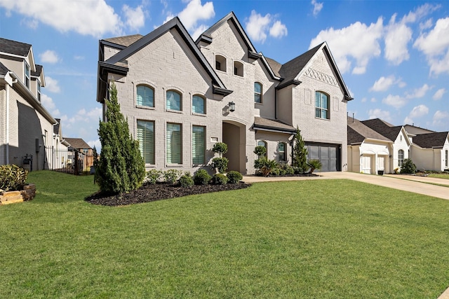 french country inspired facade with a residential view, a front yard, an attached garage, and driveway