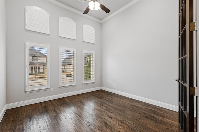 spare room featuring ceiling fan, baseboards, dark wood finished floors, and crown molding