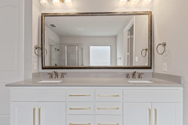 bathroom with double vanity, a stall shower, visible vents, and a sink