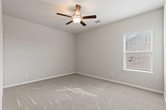 carpeted empty room with visible vents, baseboards, and ceiling fan