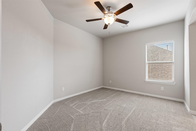 empty room with visible vents, carpet flooring, baseboards, and a ceiling fan