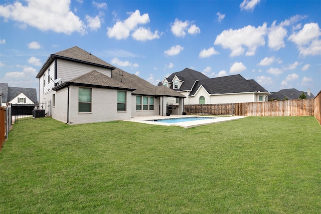 back of property with a patio, a yard, a fenced backyard, and brick siding