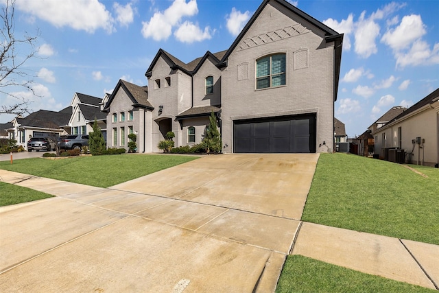 french country inspired facade with driveway, an attached garage, a residential view, a front lawn, and brick siding