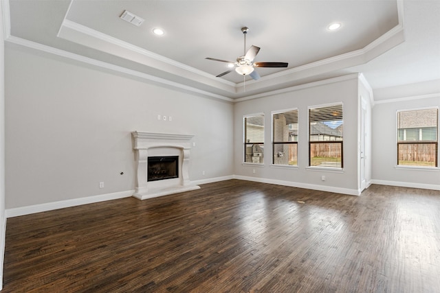 unfurnished living room with a raised ceiling, dark wood-style floors, visible vents, and ceiling fan