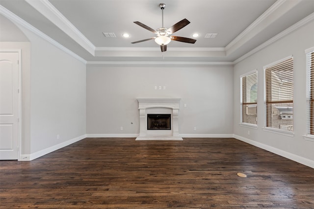 unfurnished living room with dark wood-style floors, crown molding, a tray ceiling, and ceiling fan