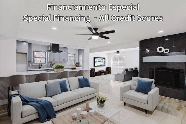 living room featuring recessed lighting, a fireplace, light wood-type flooring, and ceiling fan