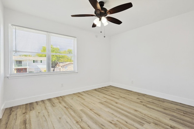 unfurnished room with baseboards, wood finished floors, and a ceiling fan