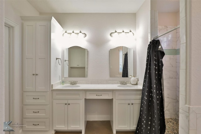 full bath with double vanity, a tile shower, and a sink