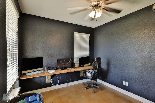 office space with baseboards, ceiling fan, and a textured wall