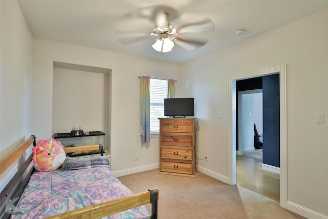 bedroom with light carpet, ceiling fan, and baseboards