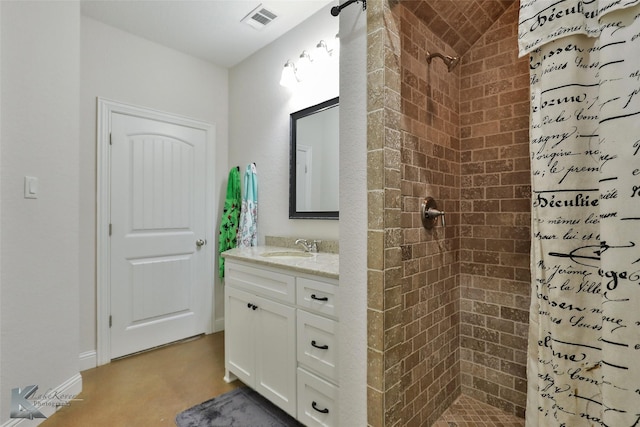 full bathroom with visible vents, tiled shower, vanity, and baseboards