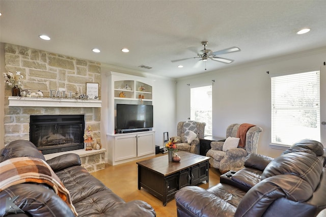 living area featuring visible vents, a textured ceiling, a ceiling fan, and crown molding