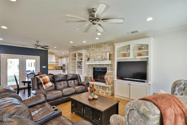 living area featuring crown molding, french doors, visible vents, and ceiling fan