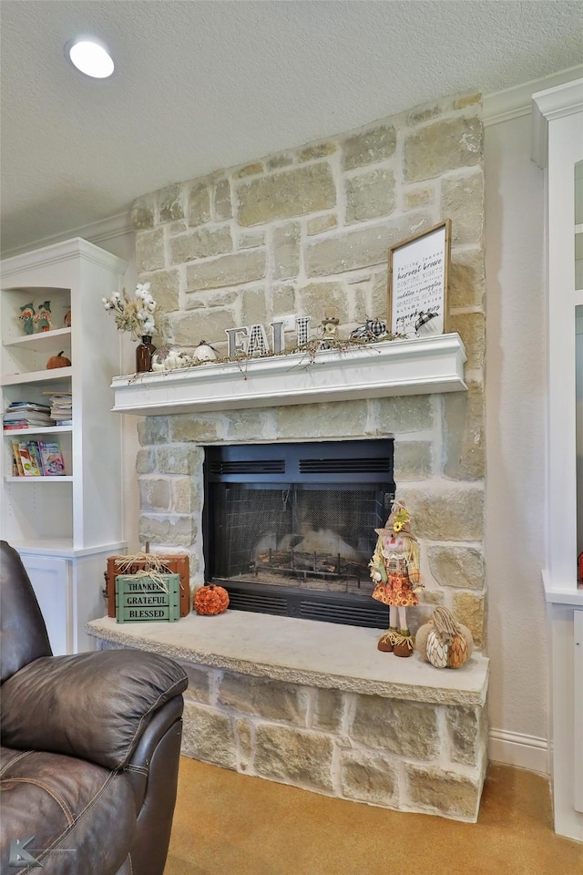 interior details featuring a fireplace, a textured ceiling, and crown molding