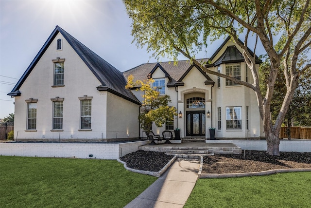 view of front of home featuring a front lawn, fence, and brick siding