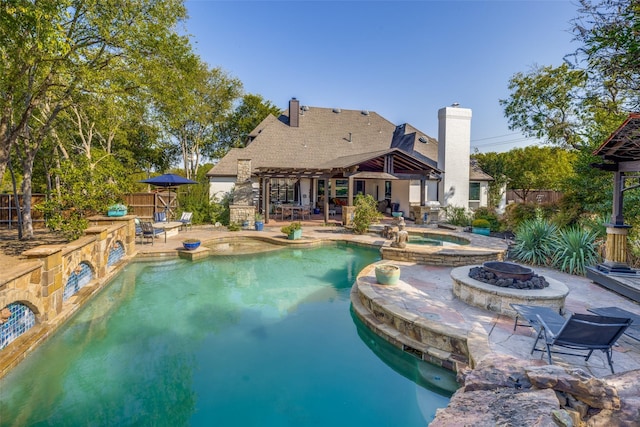 view of pool with fence, a pergola, a pool with connected hot tub, a fire pit, and a patio area