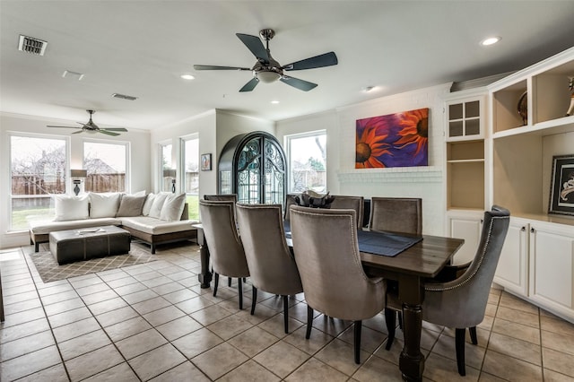 dining room with crown molding, visible vents, and ceiling fan