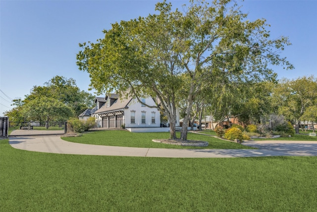 view of front of home featuring concrete driveway, a front yard, and fence