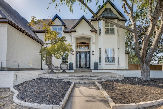 doorway to property featuring brick siding and fence