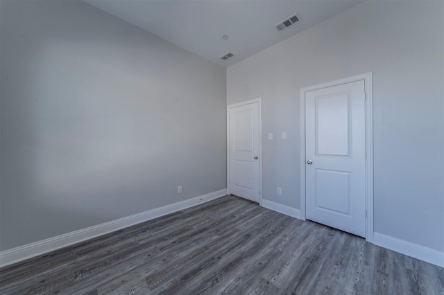 spare room featuring visible vents, baseboards, and wood finished floors
