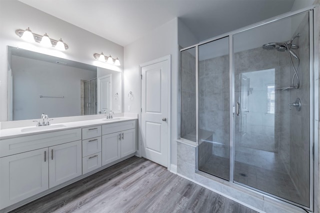full bath featuring a sink, a stall shower, and double vanity