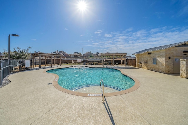 community pool with a patio area, fence, and a pergola
