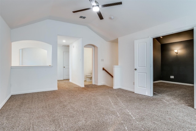 empty room featuring baseboards, ceiling fan, carpet flooring, and vaulted ceiling