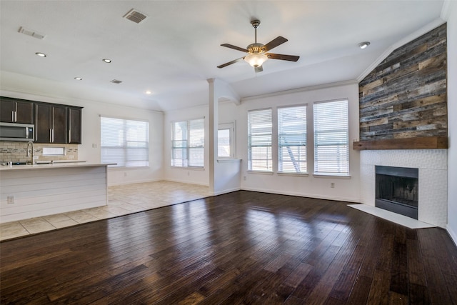 16309 Stillhouse Hollow Ct, Prosper, TX 75078 - unfurnished living room featuring visible vents, ceiling fan, light wood finished floors, a large fireplace, and lofted ceiling