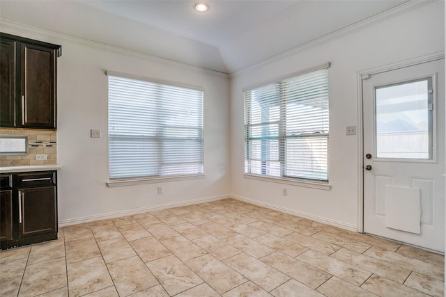 unfurnished dining area with lofted ceiling, ornamental molding, recessed lighting, light tile patterned floors, and baseboards