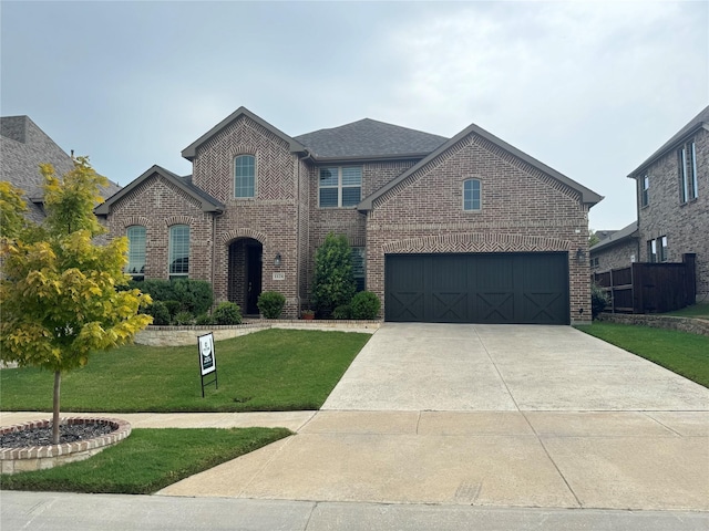 traditional-style house featuring a garage, brick siding, concrete driveway, and a front yard